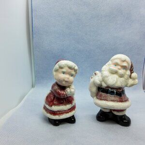 Vintage small ceramic Santa Claus holding sack and Ms. Claus holding presents